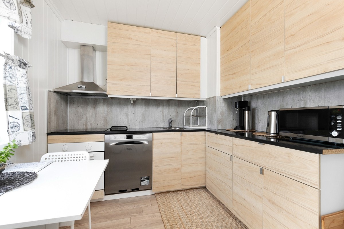 Kjøkkenet ble pusset opp i 2018 og har stilig innredning fra Ikea med slette fronter i treimitasjon. De takhøye overskapene utnytter plassen maksimalt, og det er mørk laminatbenkeplate. Galleribilde