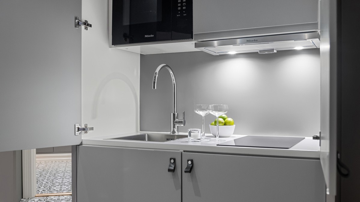 Lekkert innebygget hybelkjøkken med med kjøleskap, mikrobølgeovn m/grill og ventilator fra eksklusive Miele. Induksjonstopp med komfyrvakt og blandebatteri fra Tapwell. Galleribilde