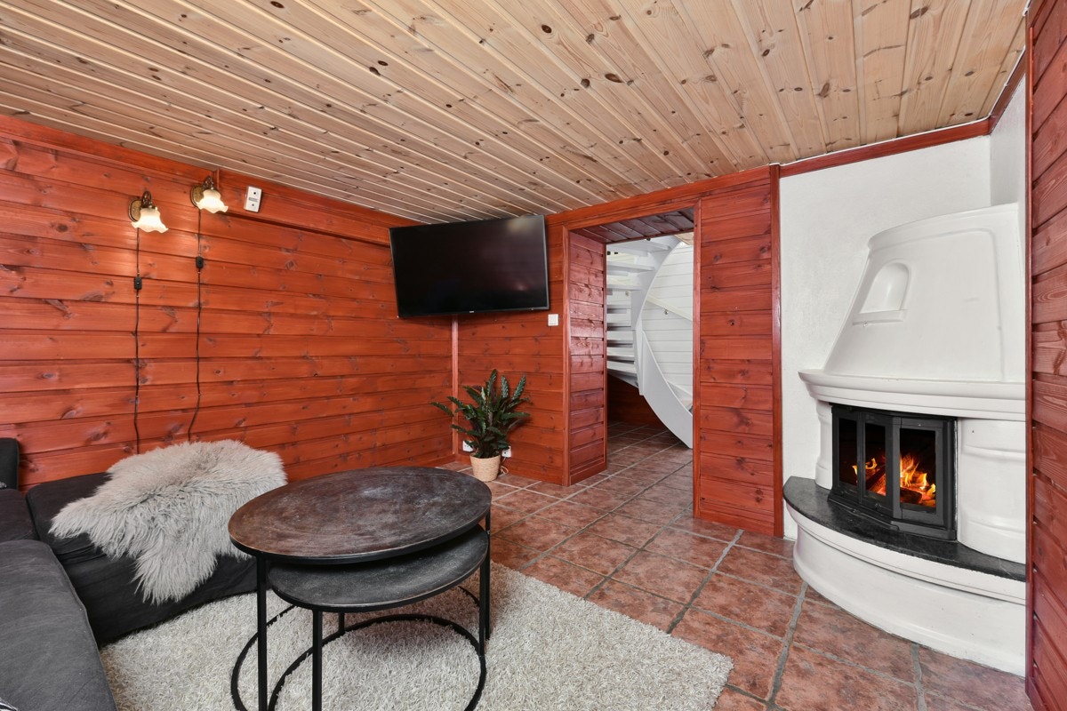 I tillegg har boligen et hyggelig, innredet rom i kjelleren. I begge rom er det fliser på gulv og rødbeiset panel på vegg. Galleribilde
