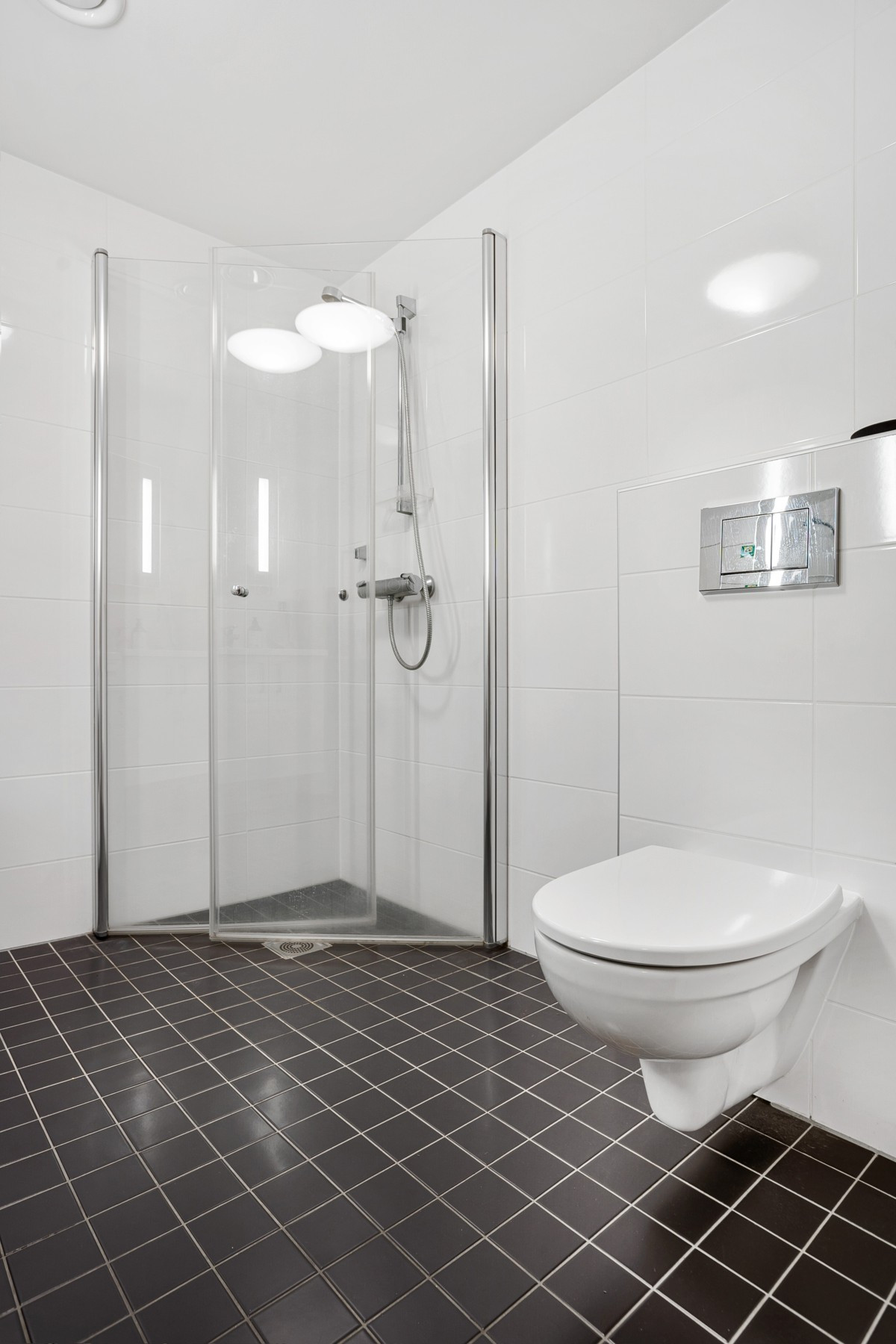 Badet er komplett flislagt med varme i gulv, dusjhjørne, vegghengt toalett og servant m/ innredning