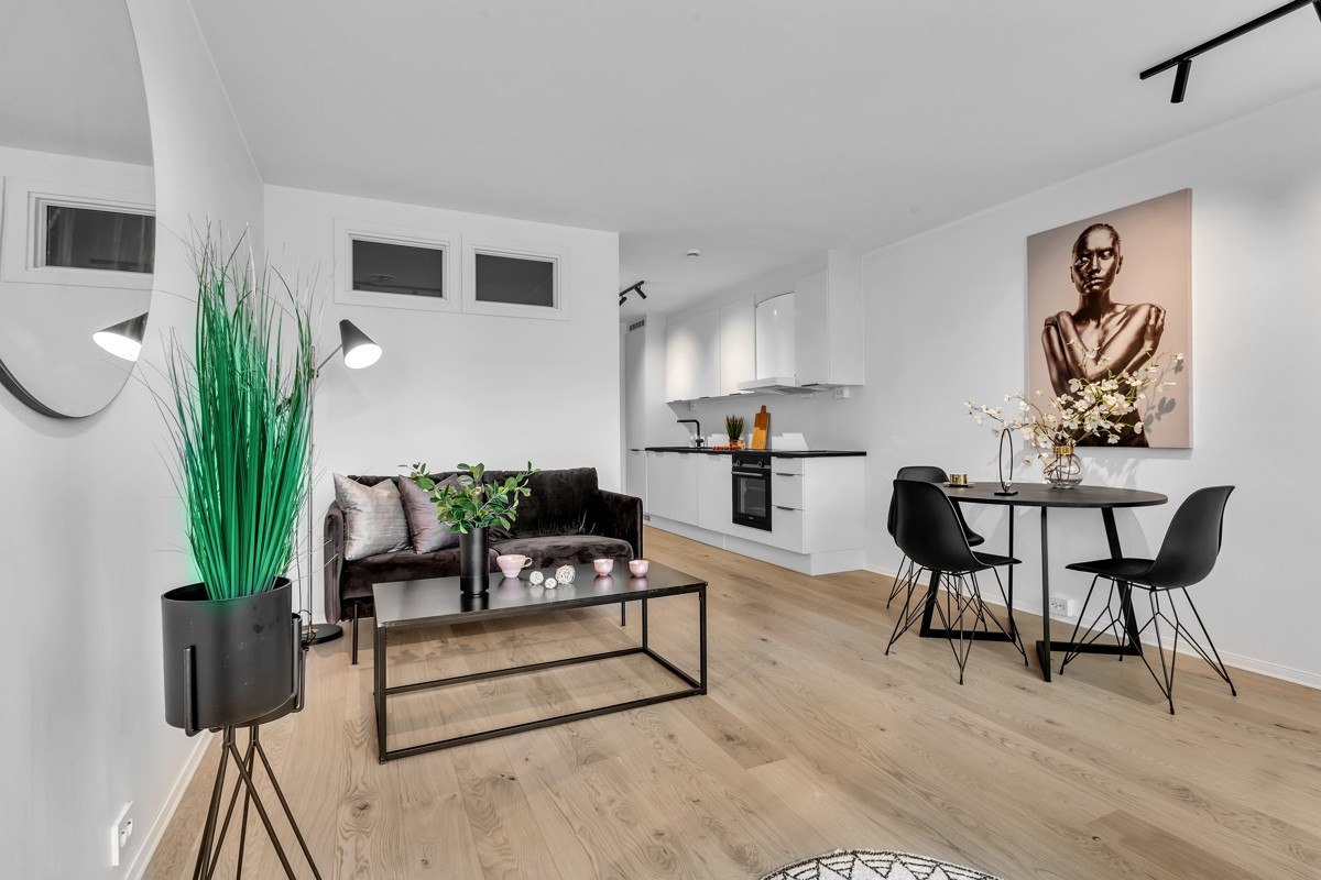 Stue og kjøkken og åpen løsning med plass for både sofagruppe og spisebord.