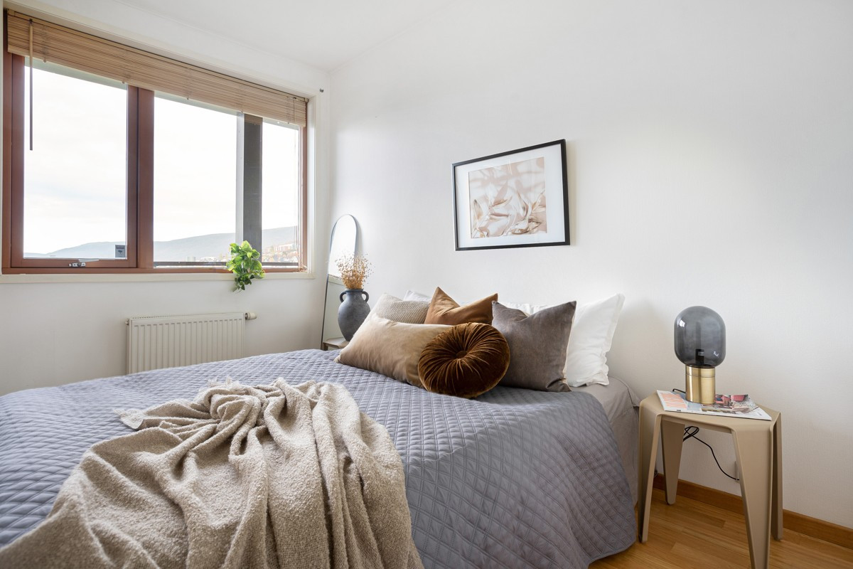 Leilighetens soverom er romslig med plass til stor seng og oppbevaringsmøbel