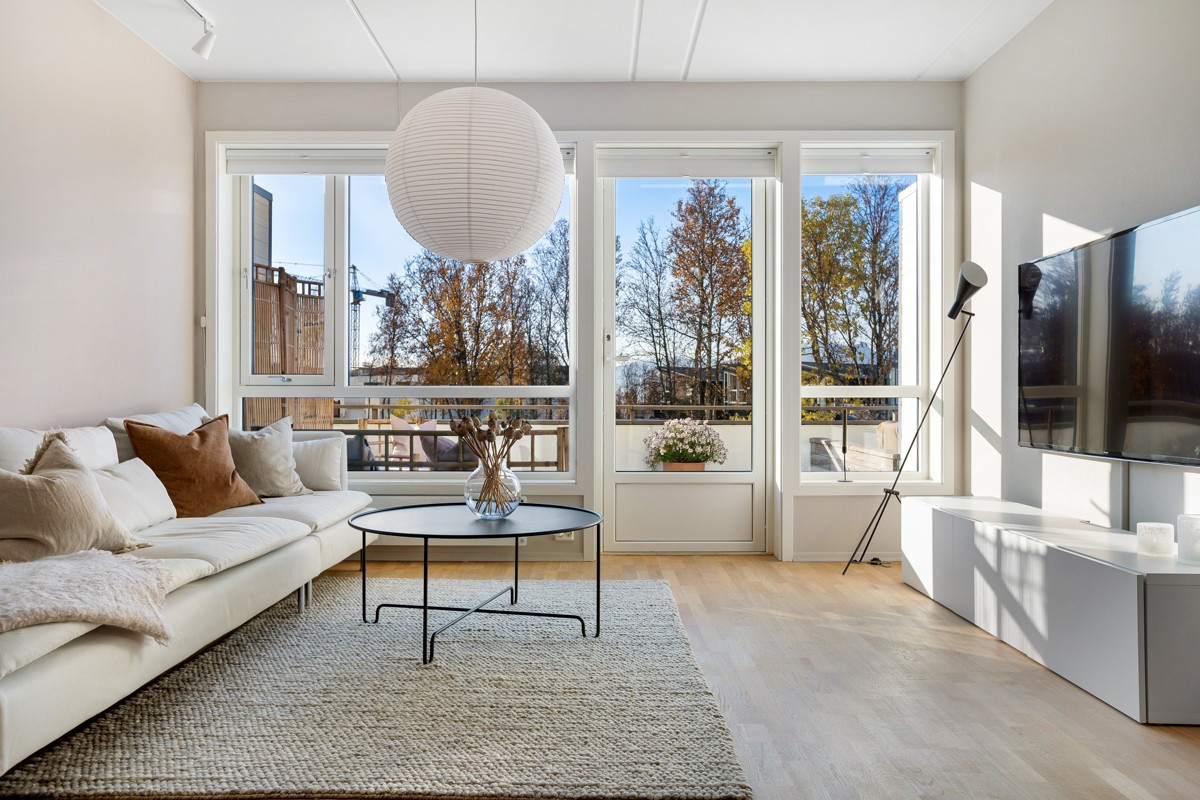 Leiligheten har store vindusflater som gir rikelig innslipp av naturlig lys