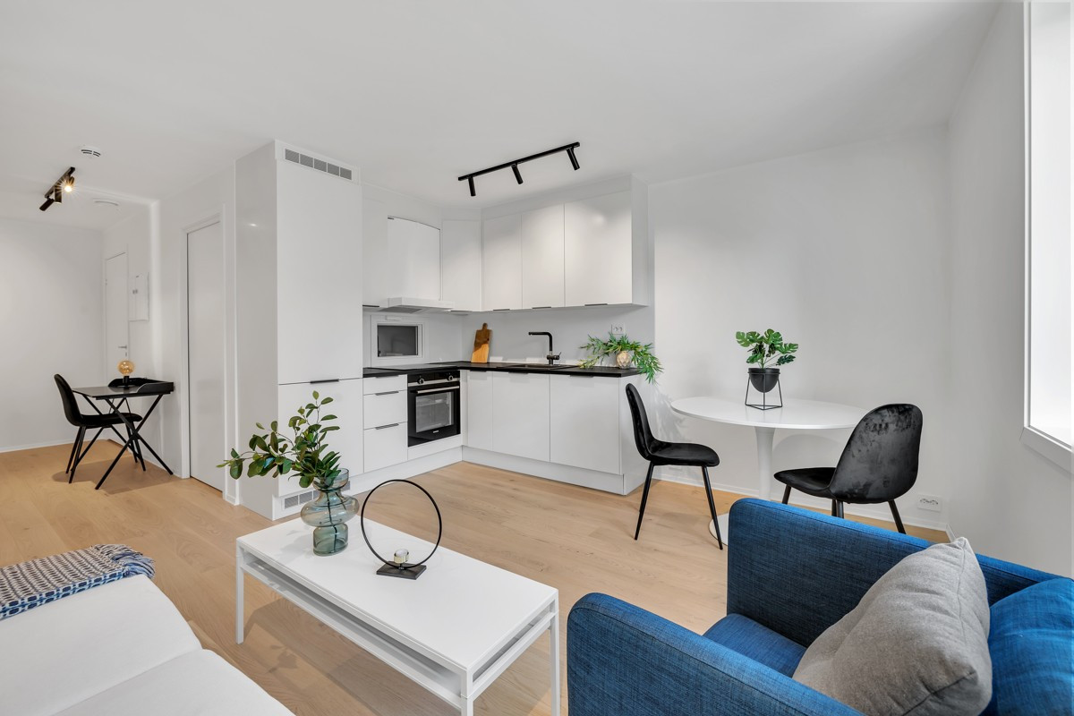 Stue og kjøkken og åpen løsning med plass for både sofagruppe og spisebord.