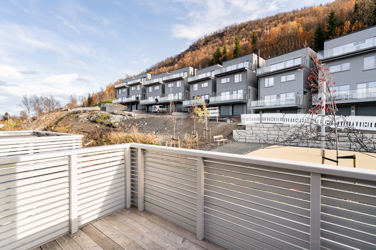 Terrasse på baksiden av boligen med utsikt over lekeplassen