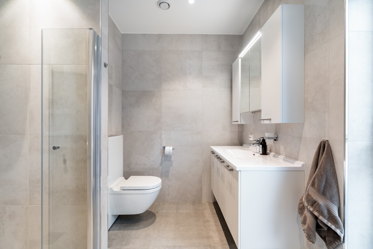 Badet er komplett flislagt med moderne innredning og varme i gulv - Legg merke til påkostet materialvalg med storformat fliser!