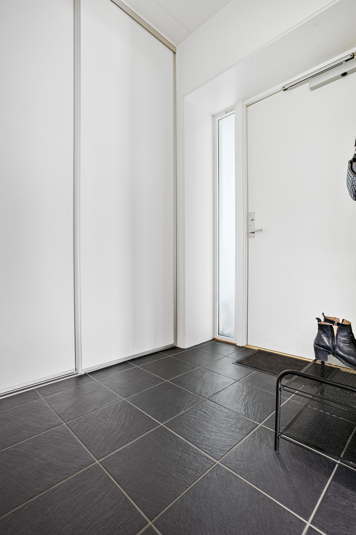 Entrè med fliser og varme i gulv- god plass til lagring av yttertøy i skyvedørsgarderobe!