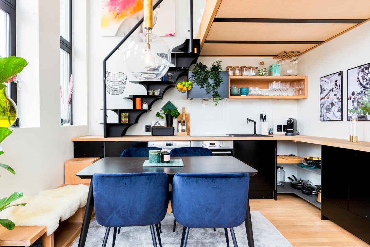 Åpen løsning mot kjøkkenet som har stilren innredning med sorte fronter og benkeplate av heltre eik. Galleribilde
