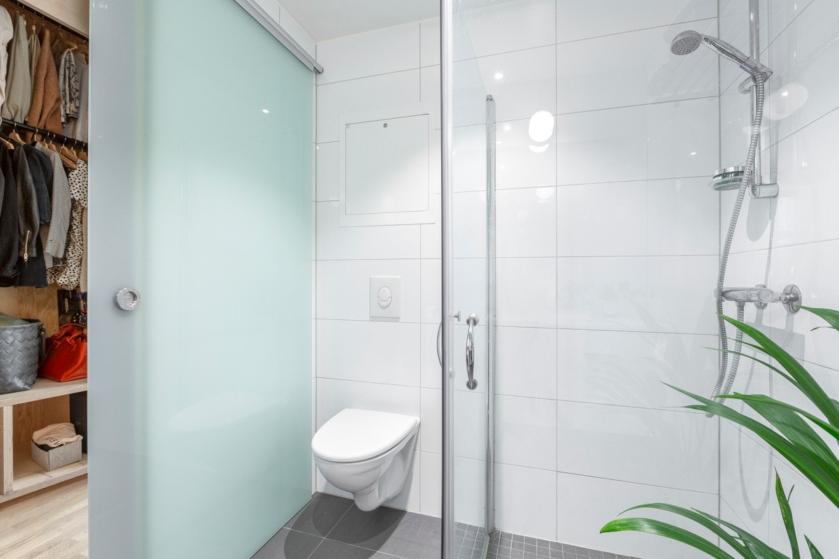 Vegghengt toalett og dusjnisje med innfellbare glassdører. Galleribilde