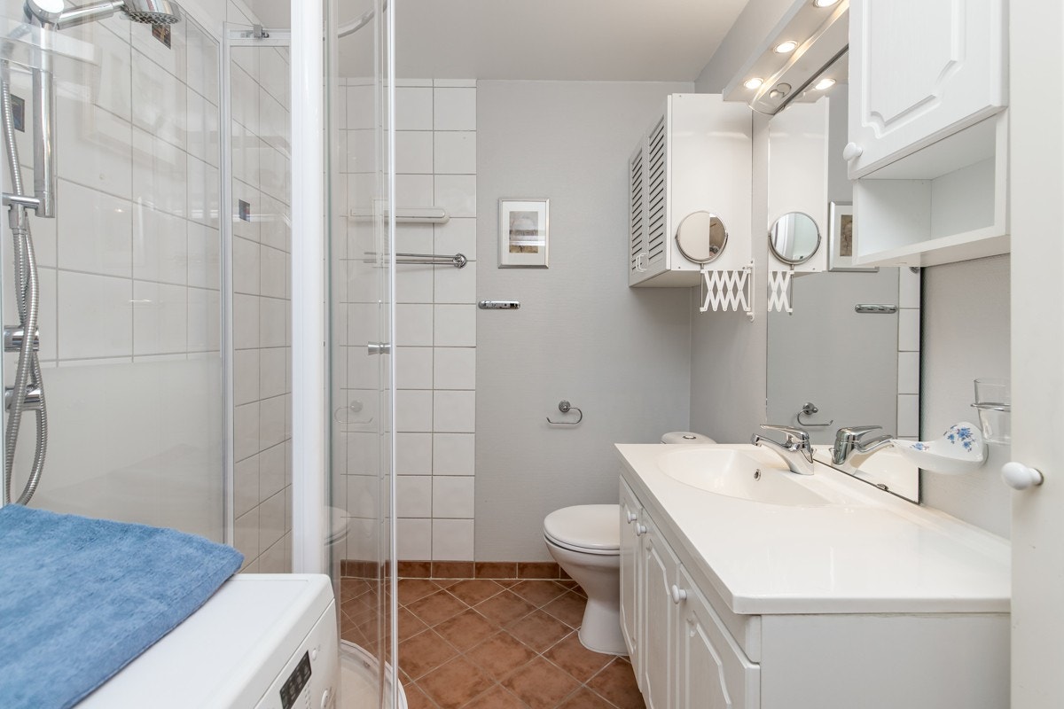 Fint bad med Dusjkabinett, servant med underskap, speil, overskap, opplegg for vaskemaskin og wc Galleribilde