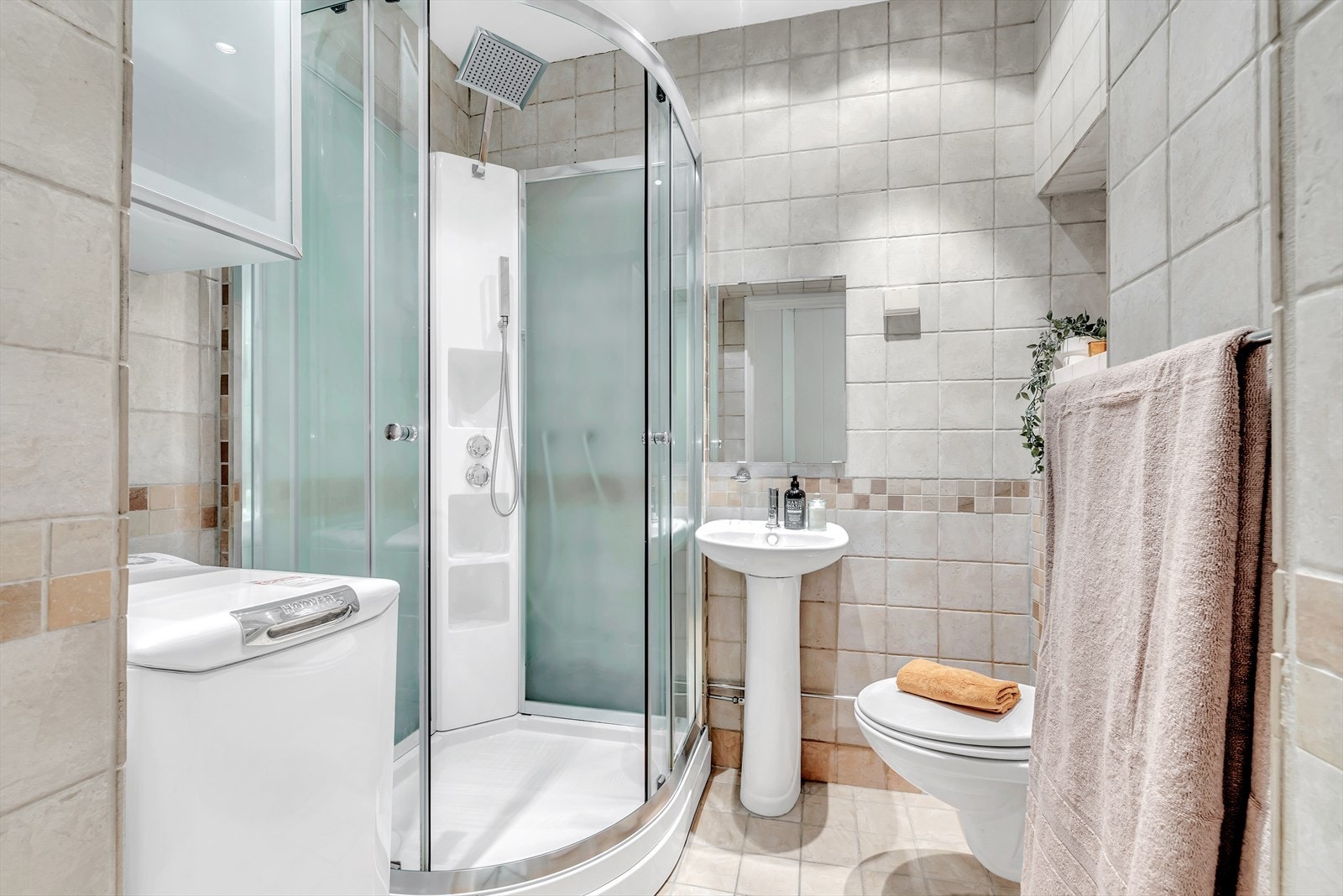 Badet er flislagt på gulv og vegger og har praktisk nisje og skap for oppbevaring. Downlights i himlingen gir godt lys og varmekabler i gulvet gir lun varme til rommet. Galleribilde