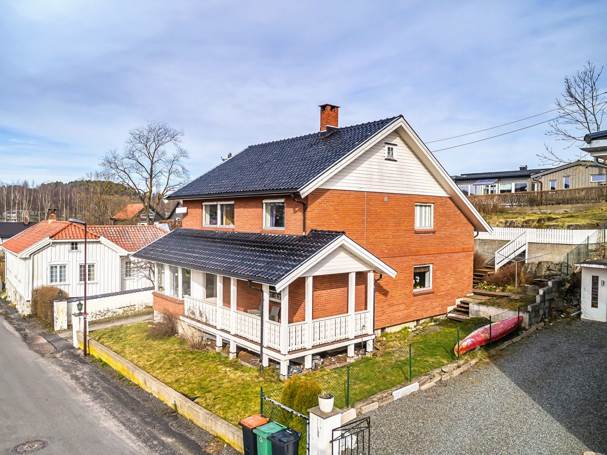 Opparbeidet uteområder med glessplen i front. Bak huset er det en nivåforskjell opp til høyere platå med utsikt. Galleribilde