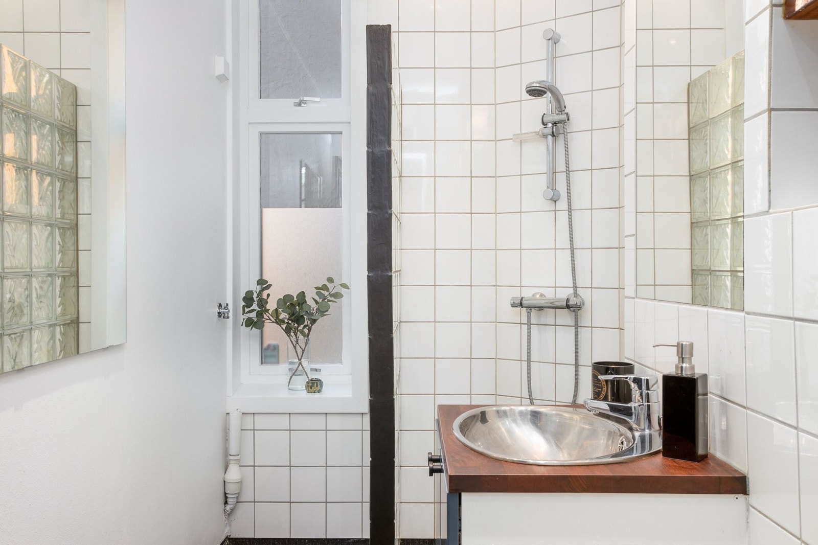 Badet er praktisk anlagt med servant i stål og dusjnisje med glassbyggerstein. Plass til vaskemaskin i eget avhuk for dette. Galleribilde