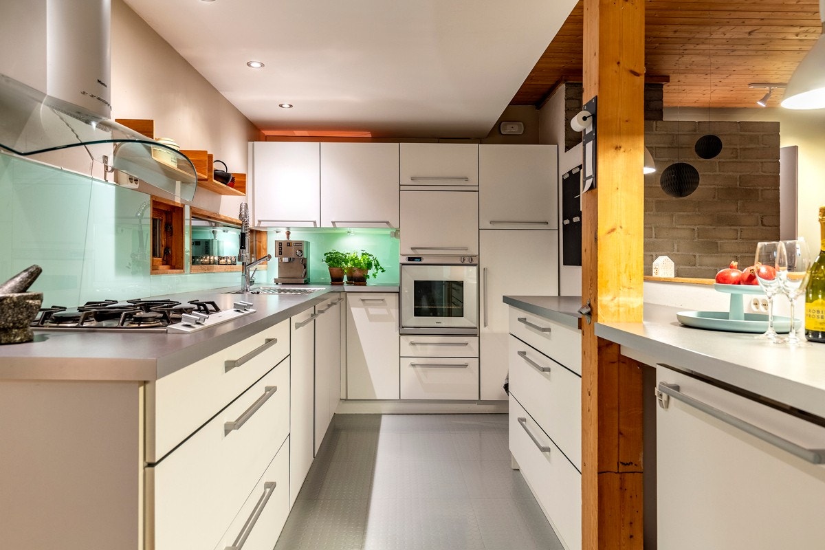Kjøkkenet har integrert Gaggenau gasskoketopp, Gaggenau stekeovn i god høyde, Miele ventilator og to innebygde kjøleskap. Galleribilde