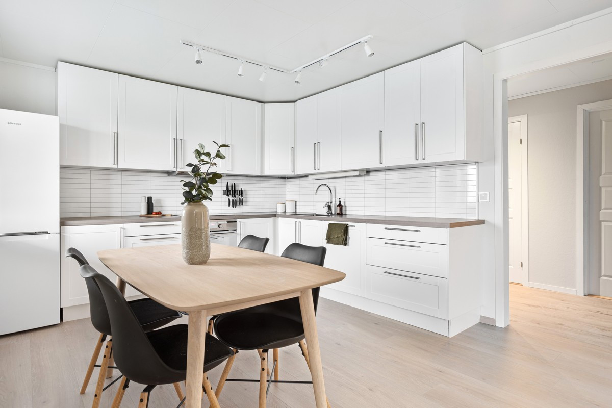 Moderne kjøkken med profilerte fabrikkmalte fronter og kitchenboard over benk