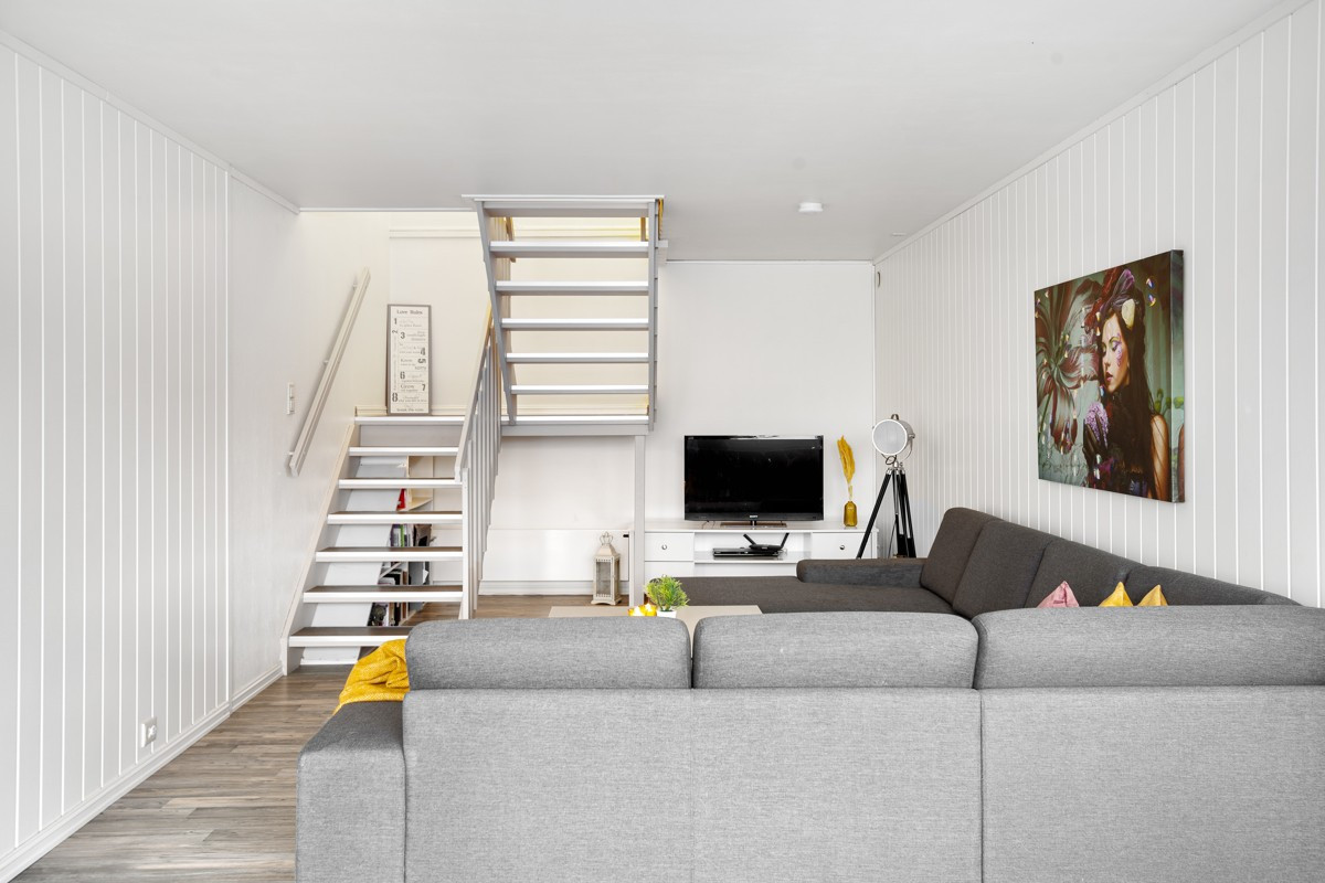 Lys og åpen stue med plass til stor sofa