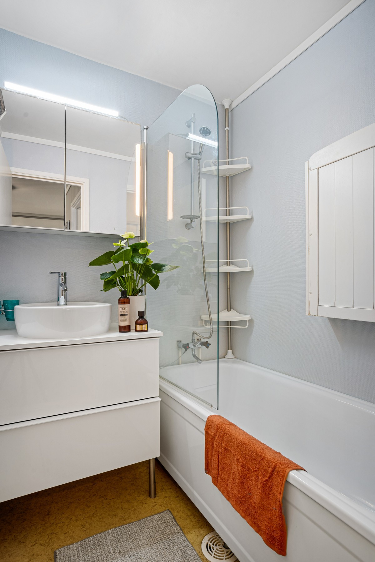Badet er separert i to deler- på det ene rommet er det dusj/badekar og servant med innredning