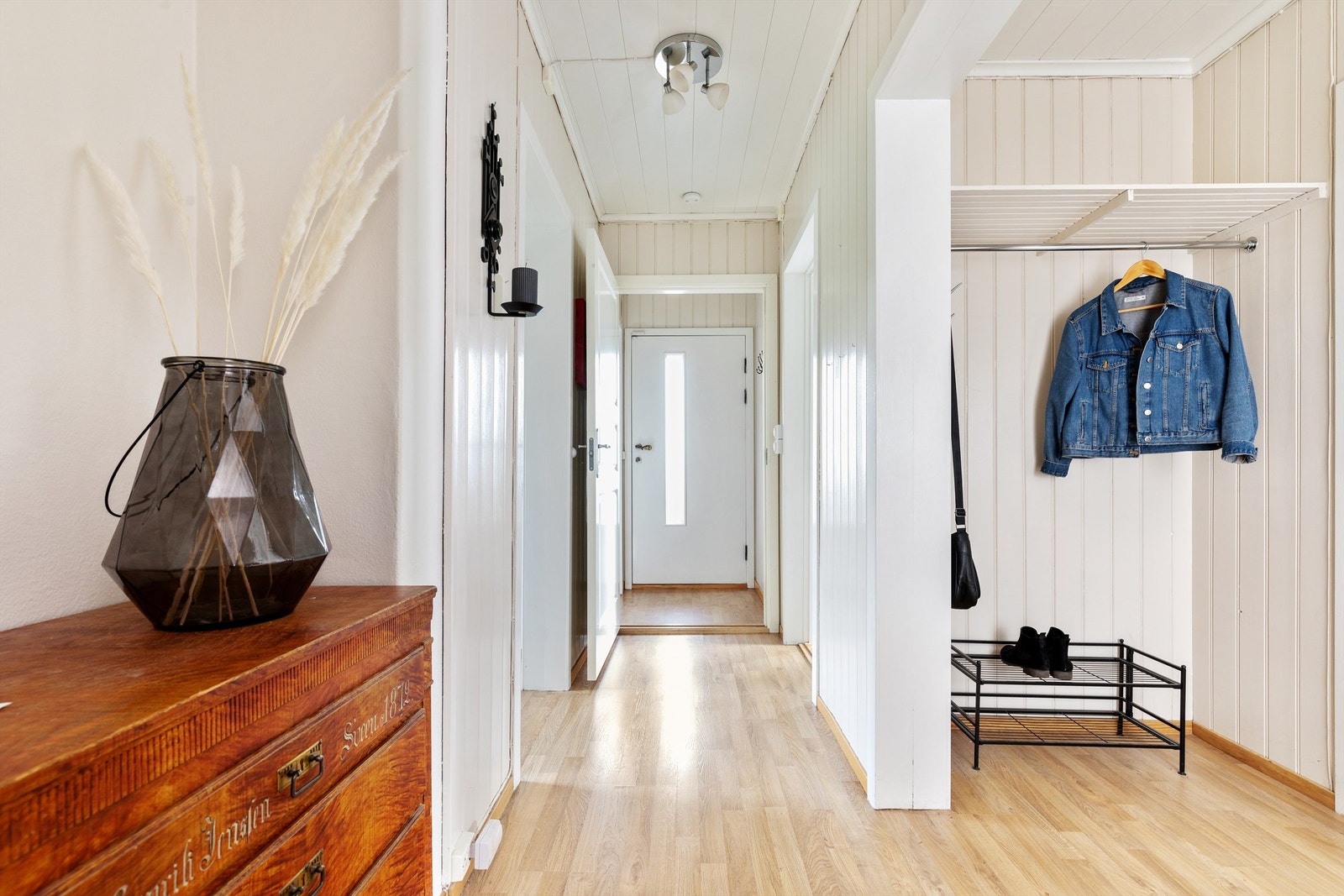 Velkommen inn i en lys og luftig entré med en praktisk garderobeløsning. Galleribilde