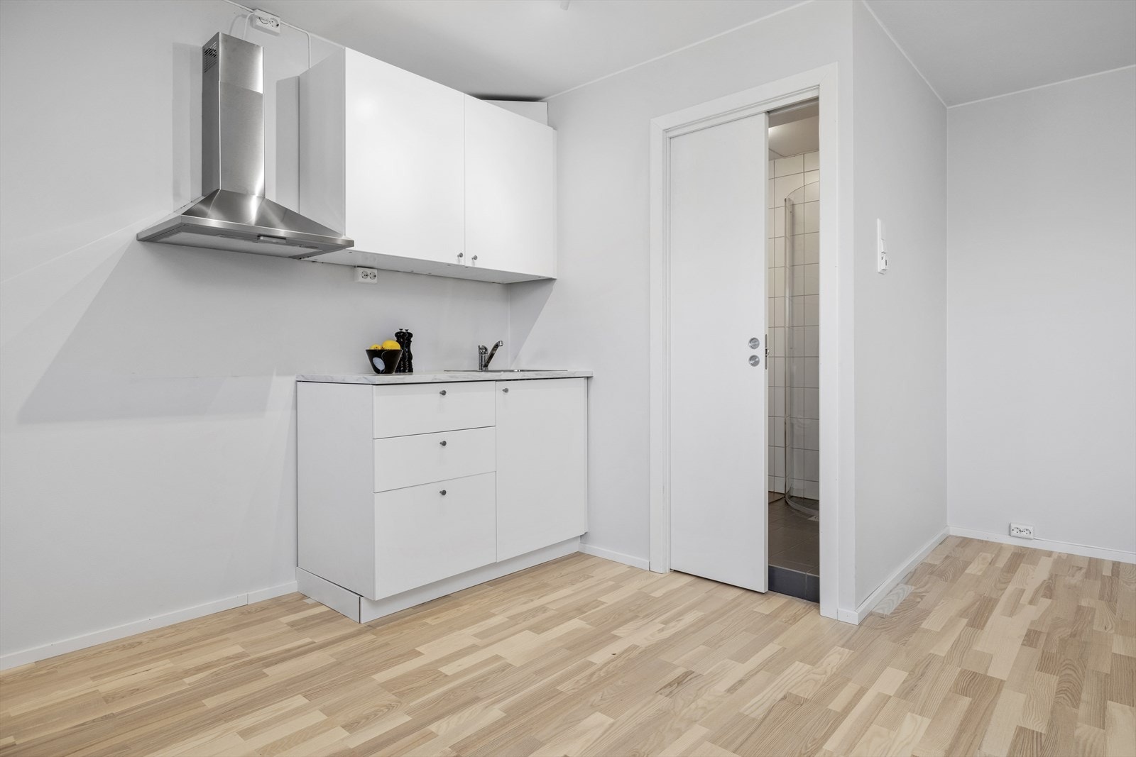 Hvit kjøkkeninnredning tilrettelagt for frittstående hvitevarer Galleribilde