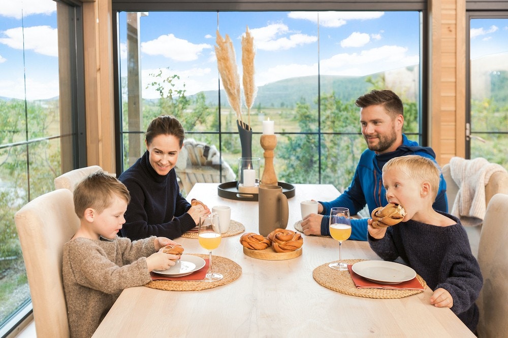 Nyt familietid ved spisebordet, mens du får naturen inn i hytta med store vinduer Galleribilde