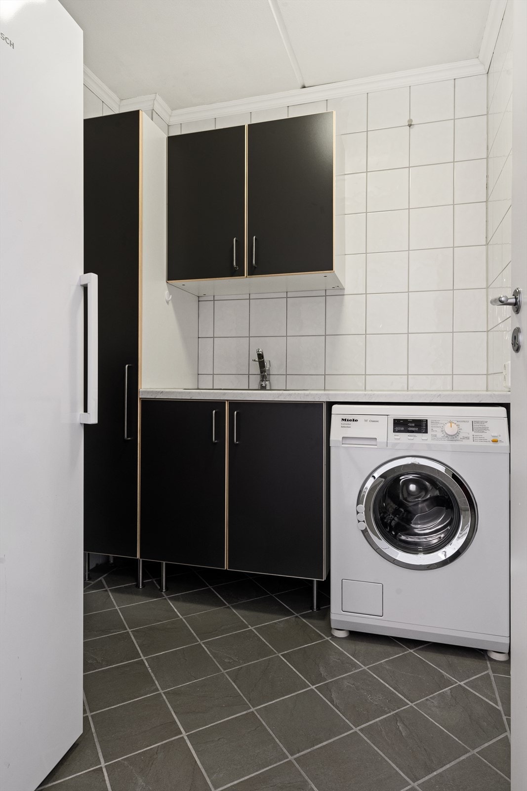 Meget praktisk vaskerom med varmekabler i gulv og opplegg for både vaskemaskin og tørketrommel samt utslagsvask. Galleribilde