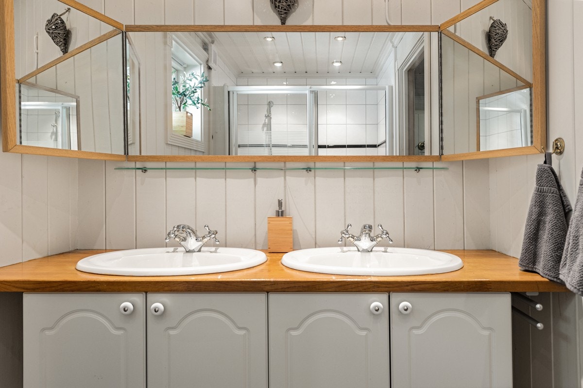 Dusjnisje med glassvegg og dør. Innredning med to servanter. Galleribilde