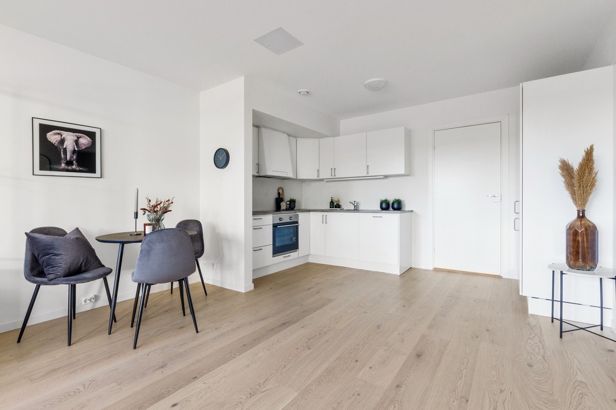 Kjøkkenet består av en lys- og lakkertinnredning med integrerte hvitevarer. Galleribilde