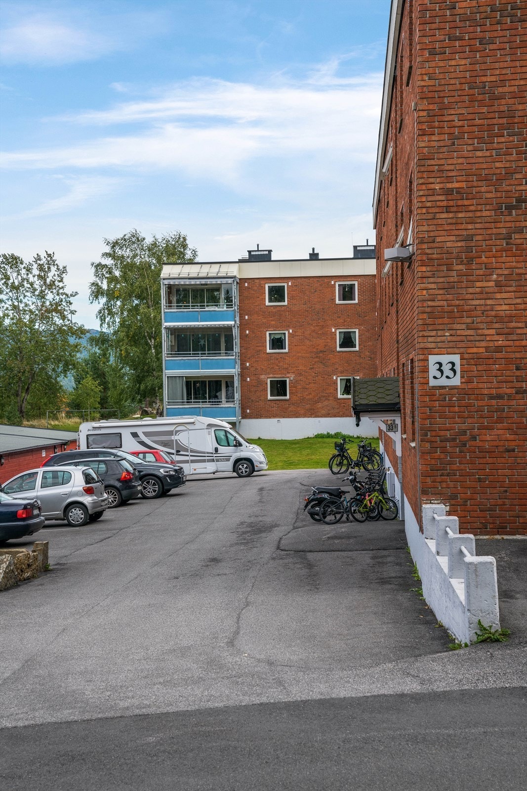 Det er felles parkeringsplass på utsiden av blokka. Galleribilde