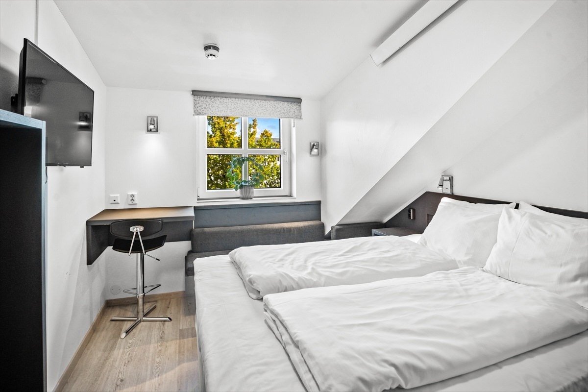 Rommet har en deilig dobbeltseng, en liten sofakrok samt en praktisk arbeidsplass. Galleribilde
