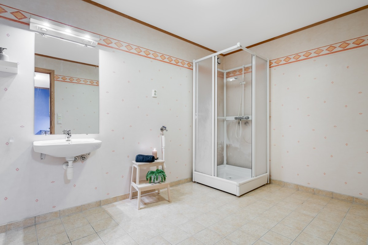 Badet i underetasjen er innredet med dusj og servant, og har direkte inngang til toalettrom med et toalett og servant.