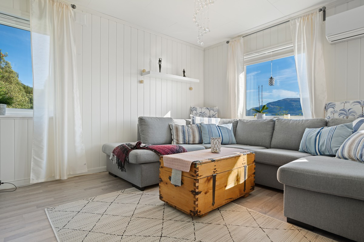 Romslig stue med naturlige soner for sittegrupper og spisebord.