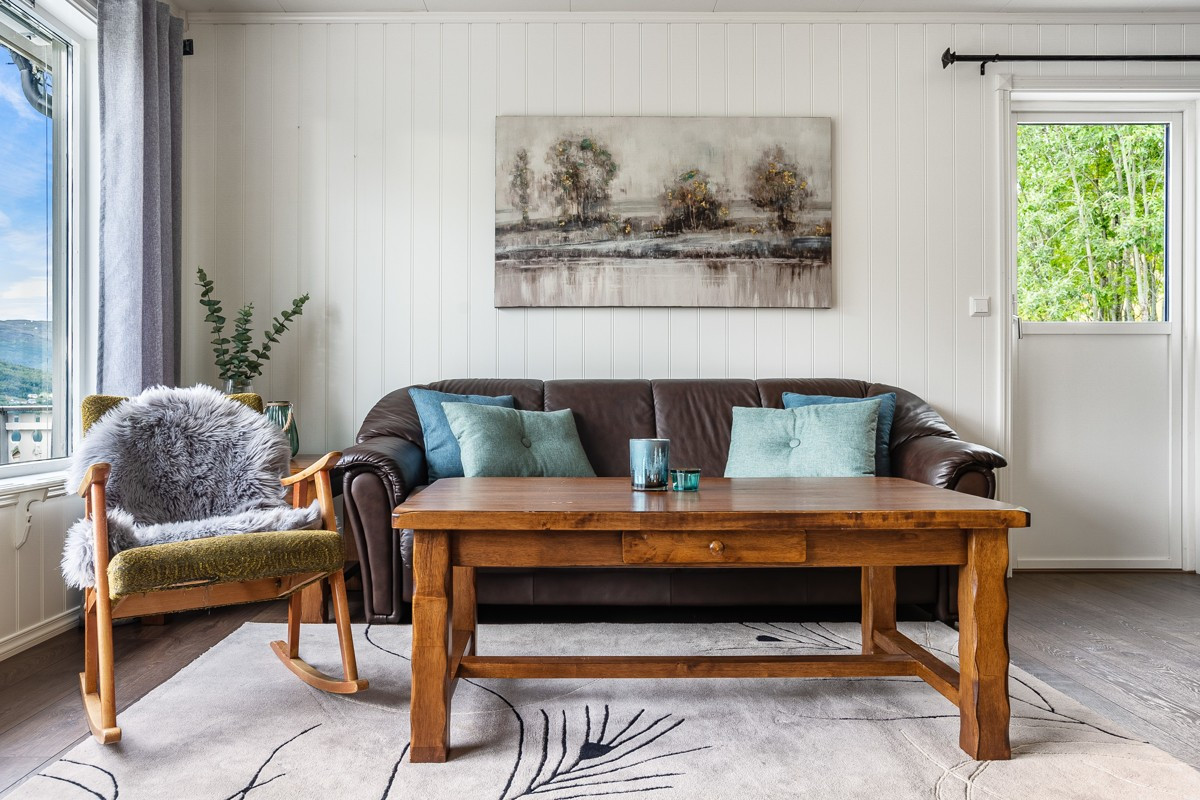 Stue/kjøkken i delvis åpen løsning med naturlige soner for innredning.