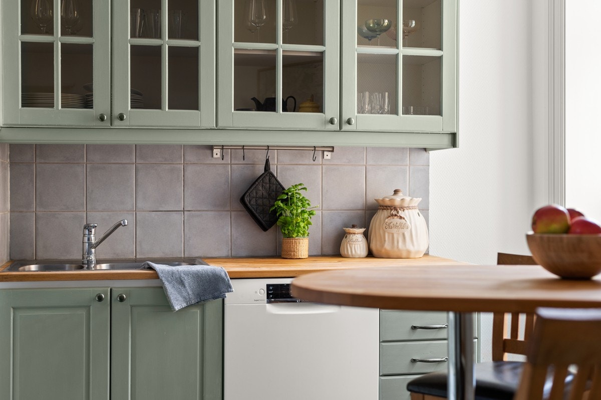 Sjarmerende kjøkkeninnredning med profilerte fronter malt i en fin grønnfarge i 2020 og heltre benkeplate med nedsenket oppvaskkum. Galleribilde