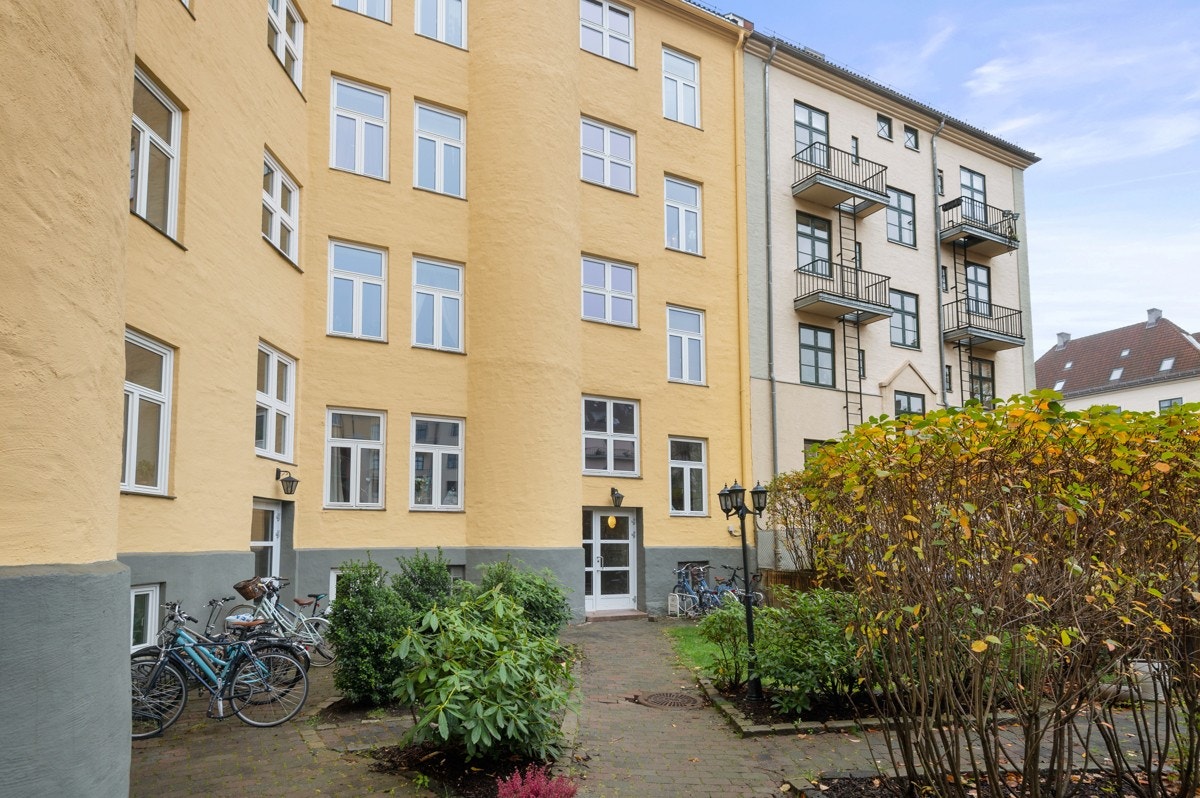 Felles tomt for borettslaget opparbeidet med asfalterte og steinlagte internveier, trær og diverse beplantning. Sittegrupper og sykkelparkering. Galleribilde