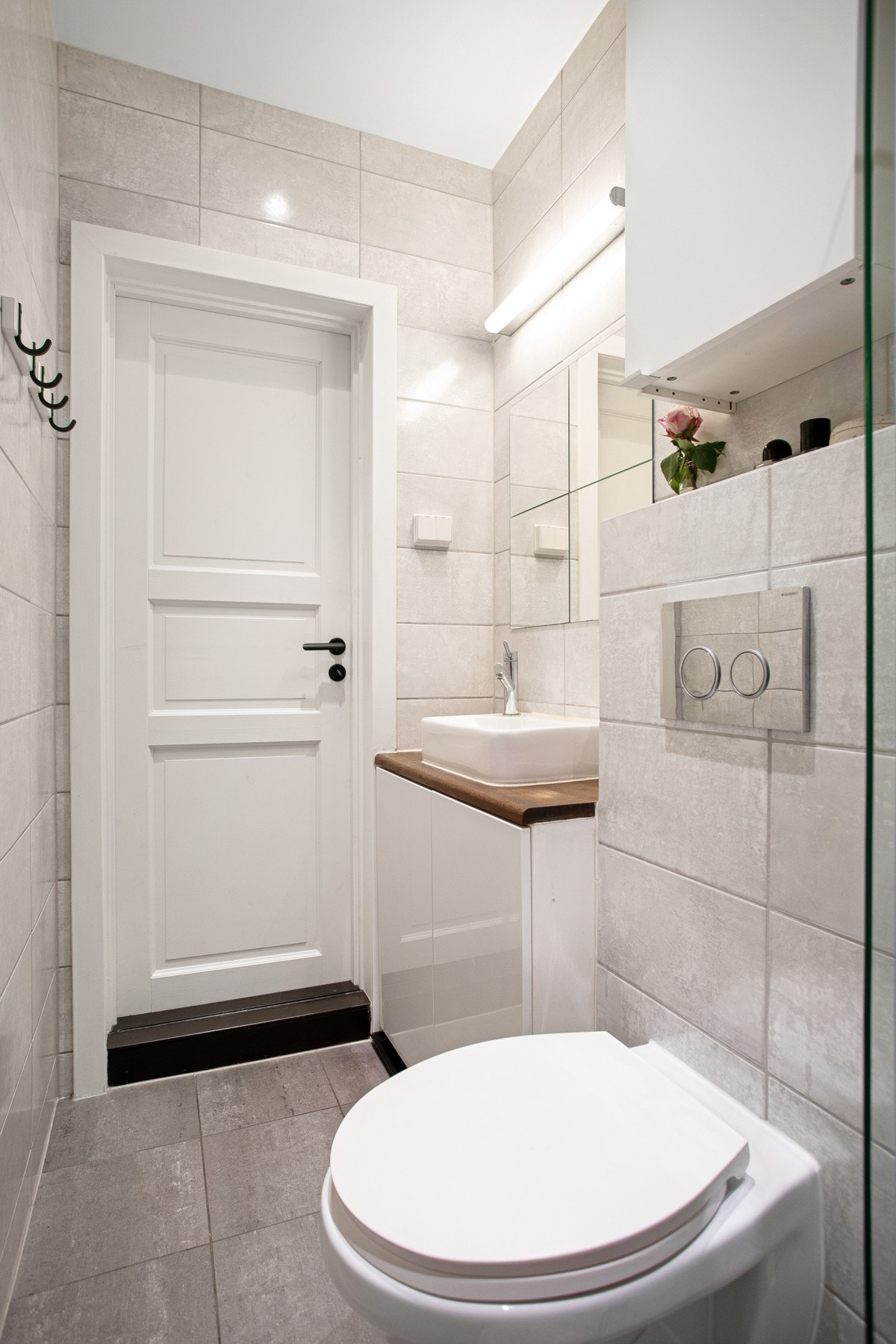 Pen baderomsinnredning med benkeplate i tre og ovenpåliggende servant, speil med belysning over. Opplegg for egen vaskemaskin i kjeller. Galleribilde