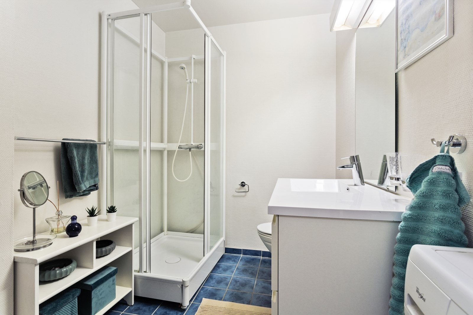 Lyst baderom med varme i gulvet og opplegg for vaskemaskin. Galleribilde