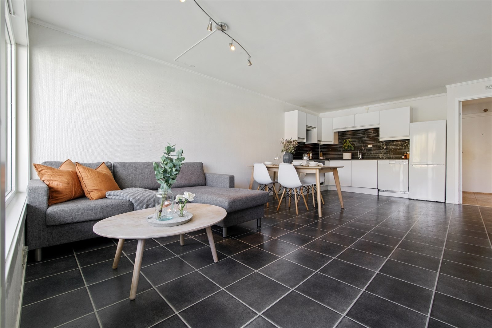 Stuen blir et sosialt rom med en åpen løsning til kjøkkenet. Her er det laminat på gulv og et lyst fargevalg på vegger. Galleribilde