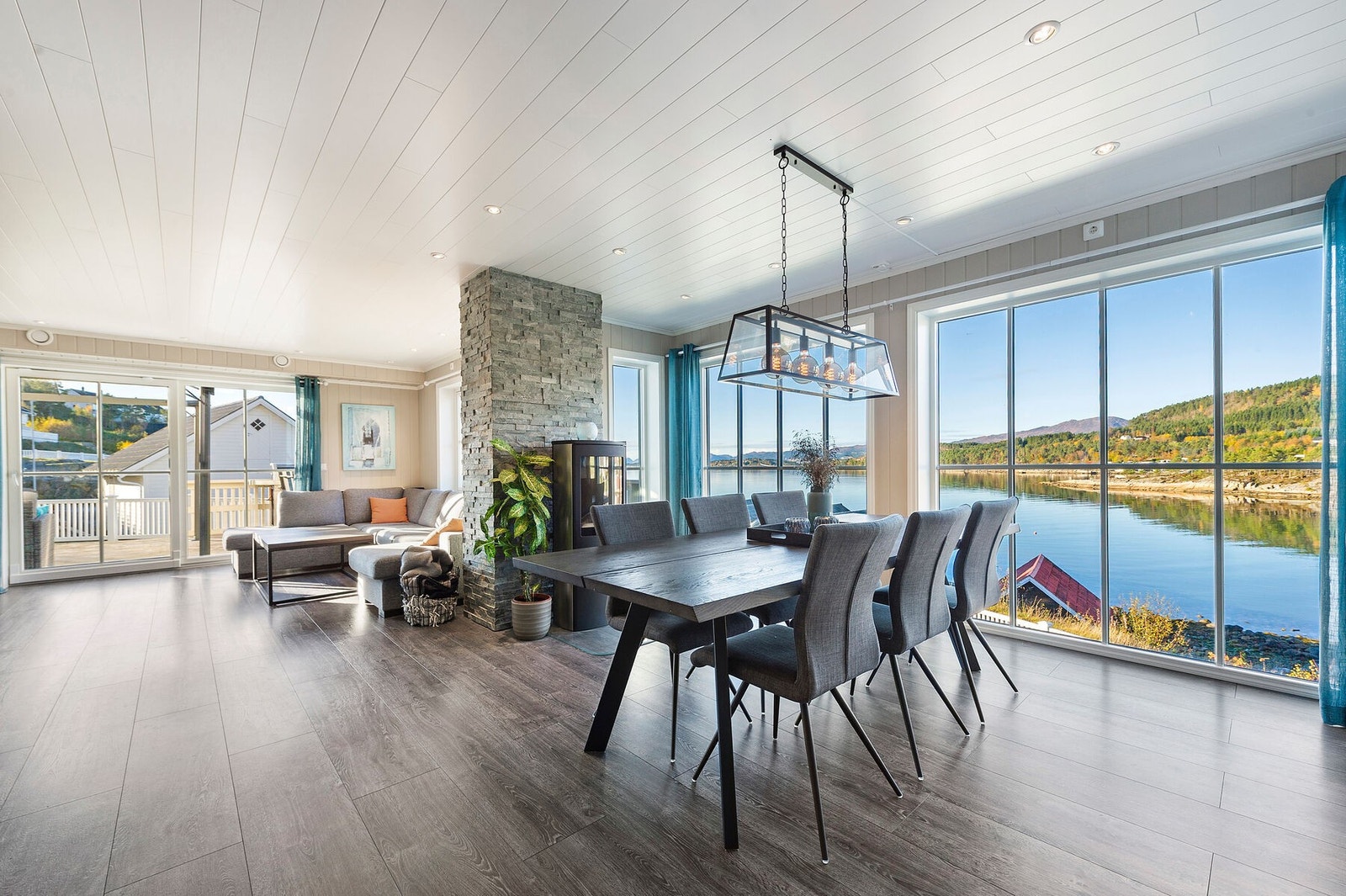 Stue i hovedetasje med store vindusflater til å nyte sjøutsikten Galleribilde