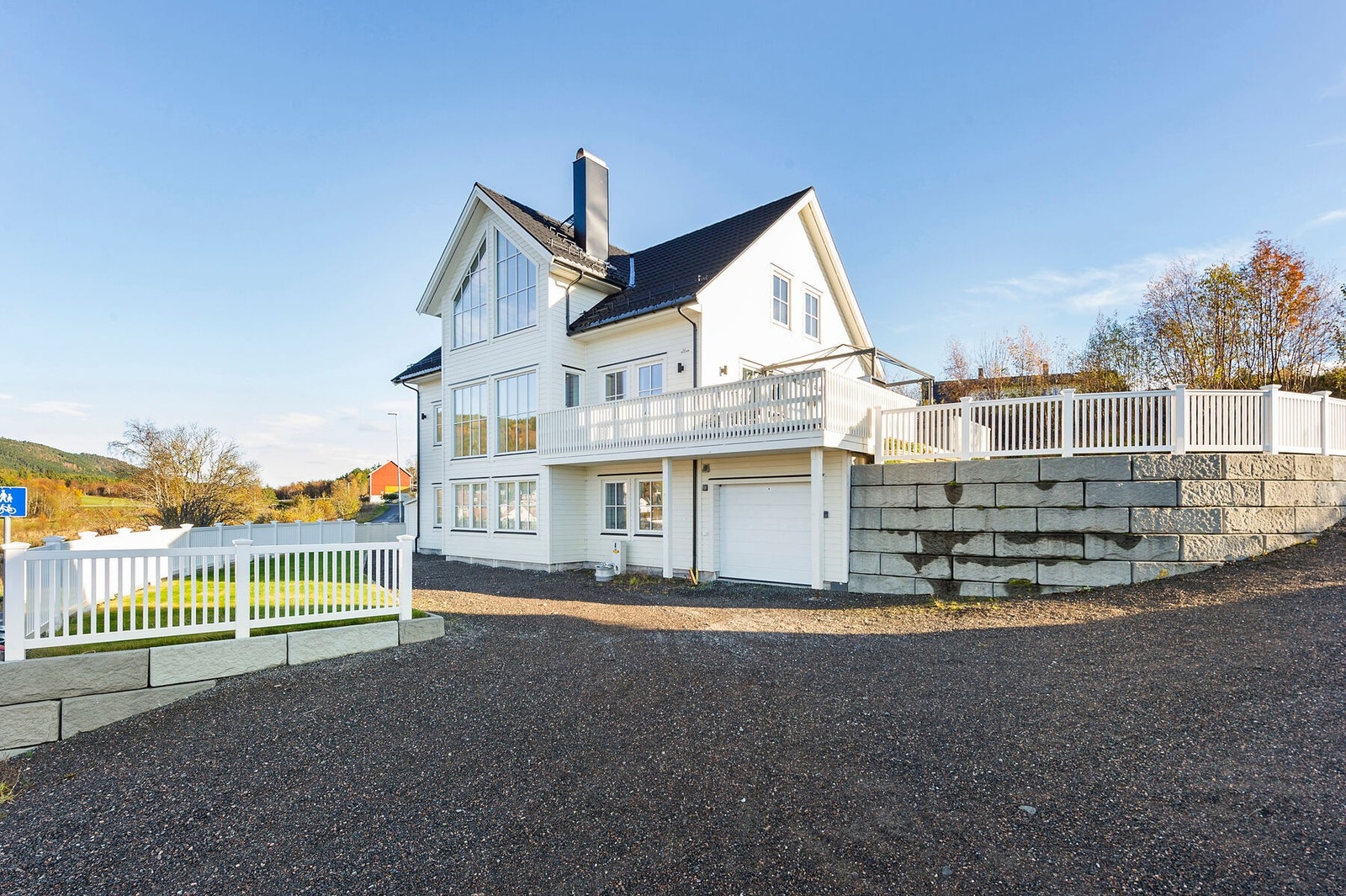 Gruset innkjørsel med garasje og god plass til oppstilling av flere biler Galleribilde