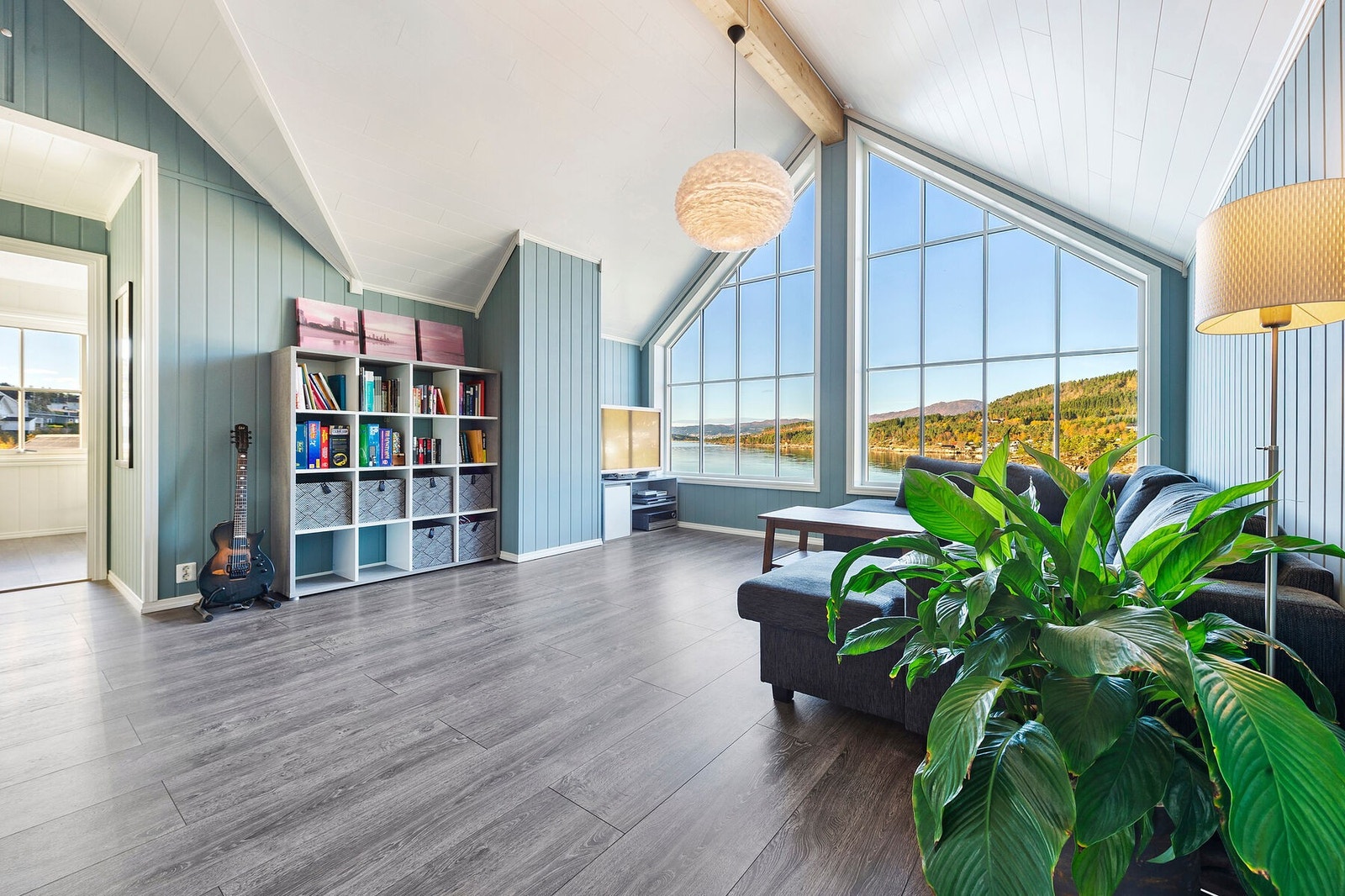 De store vindusflatene og takhøyden gjør loftstuen luftig Galleribilde