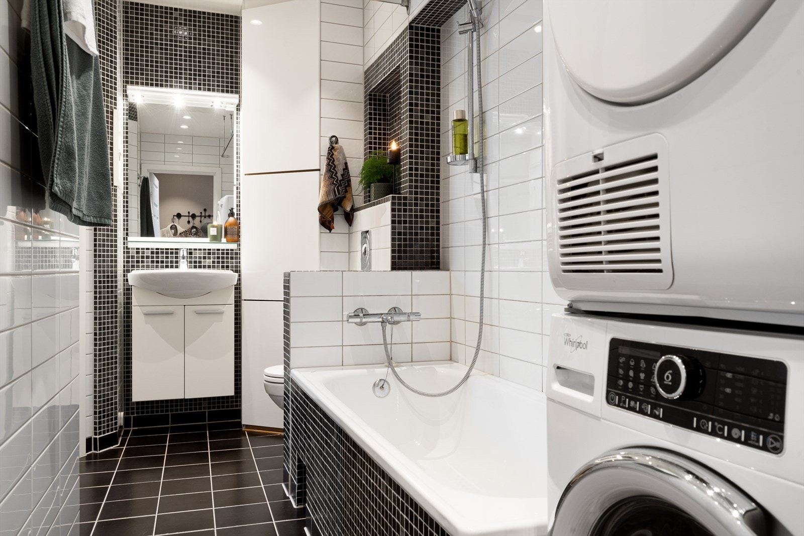 Pent baderom med flislagte overflater, gulvvarme og nedsenket himling med downlights. Opplegg for vaskemaskin og tørketrommel. Plassbygd hjørneskap på bad med ekstra oppbevaring Galleribilde