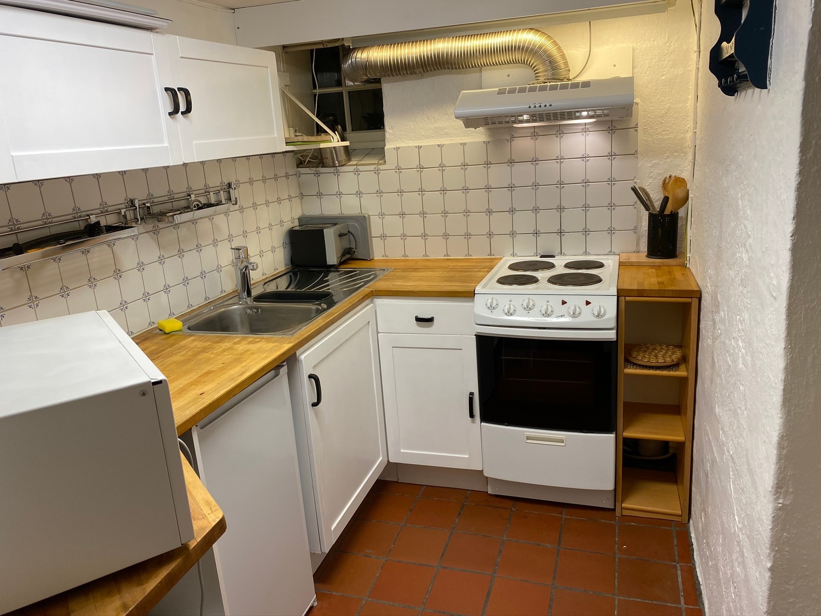 Kjøkken med komfyr, mikrobølgeovn og kjøleskap Galleribilde