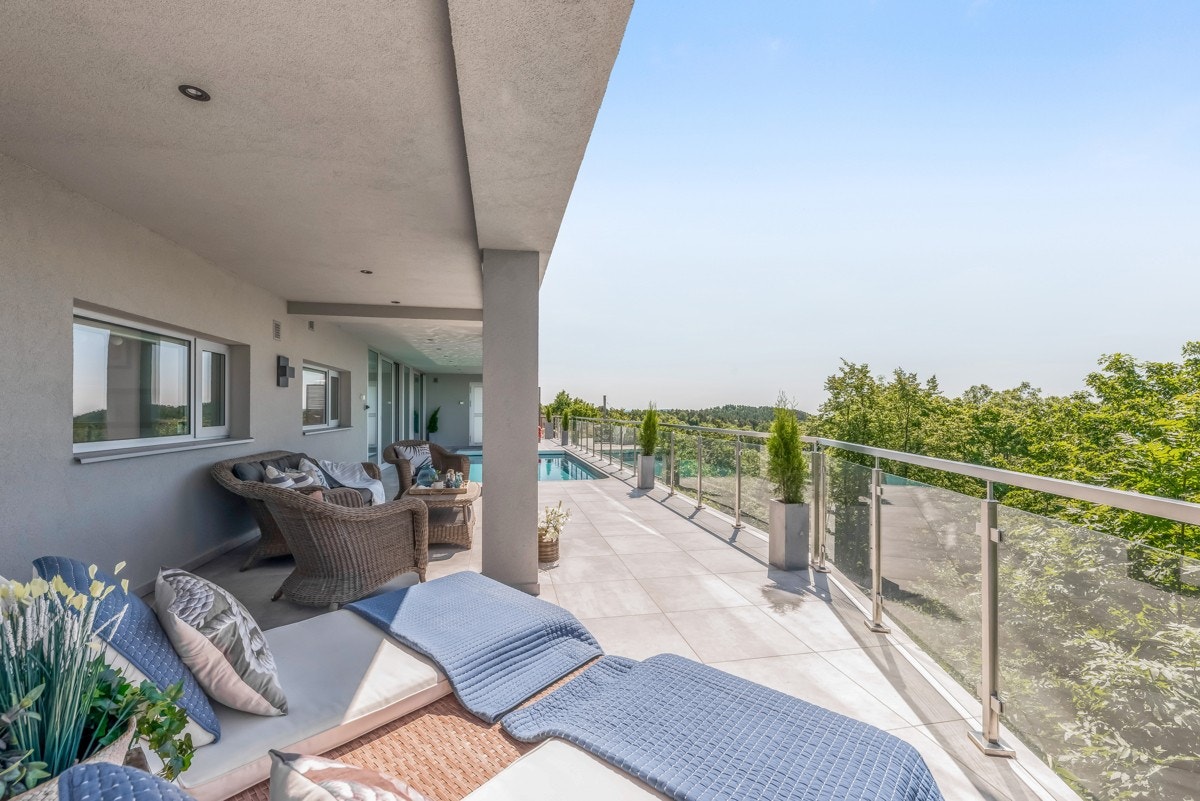 Balkonggulvet har fliser og varmekabler og det er glassrekkverk. Galleribilde