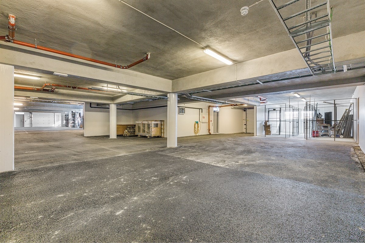 Garasjeanlegget har gode parkeringsplasser og adkomst via motorisert port og dør til inngangspartiet. Her er også de utvendige bodene til hver leilighet plassert. Galleribilde