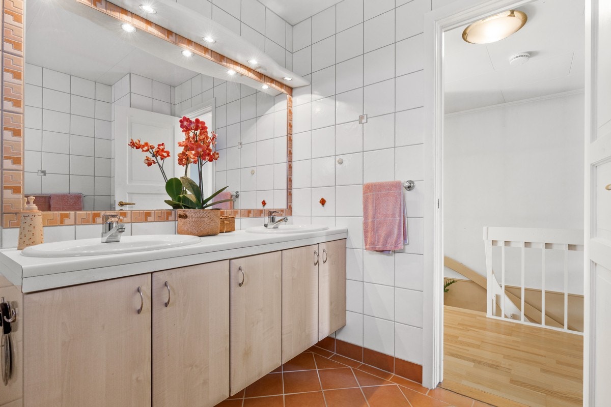 Badet er innredet med dobbel servant innredning med skap og speil med overbelysning. Galleribilde