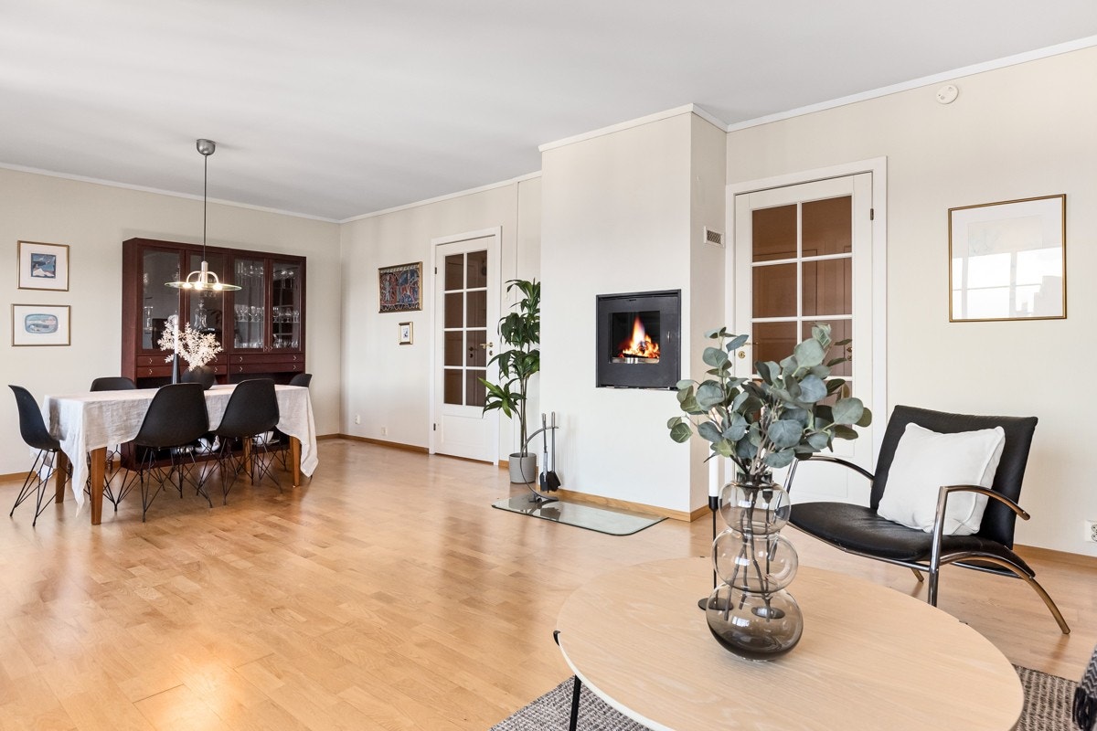 Et flott ildsted skiller stue og spisestue på en åpen og tiltalende måte. Galleribilde