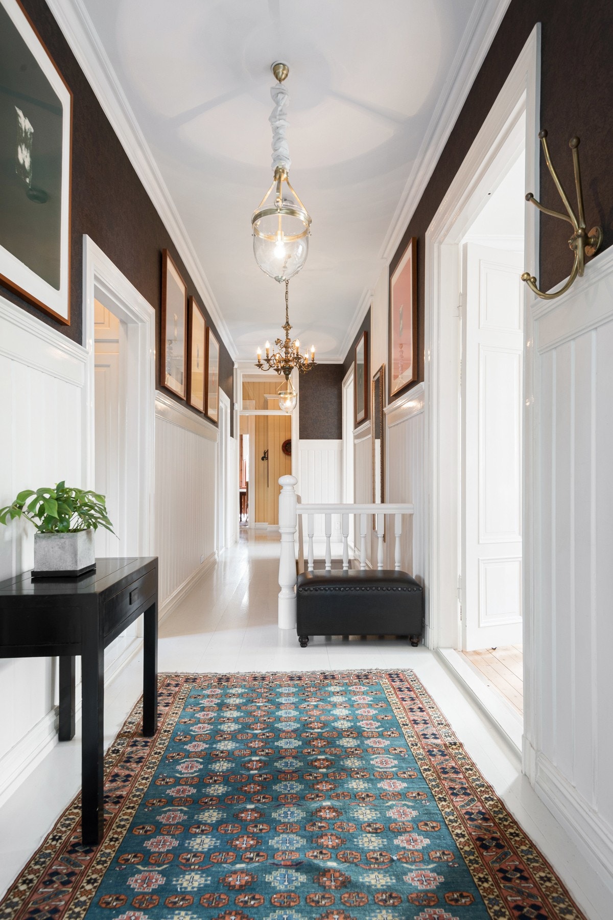 Seksjonen har inngang via første etasje, og her får du et særs hyggelig førsteinntrykk i entreen. Det er lysmalte tregulv og brede brystningspanel som fremhever den flotte takhøyden i rommet. Plassbygde skap for oppbevaring av yttertøy ved inngangsdør. Galleribilde