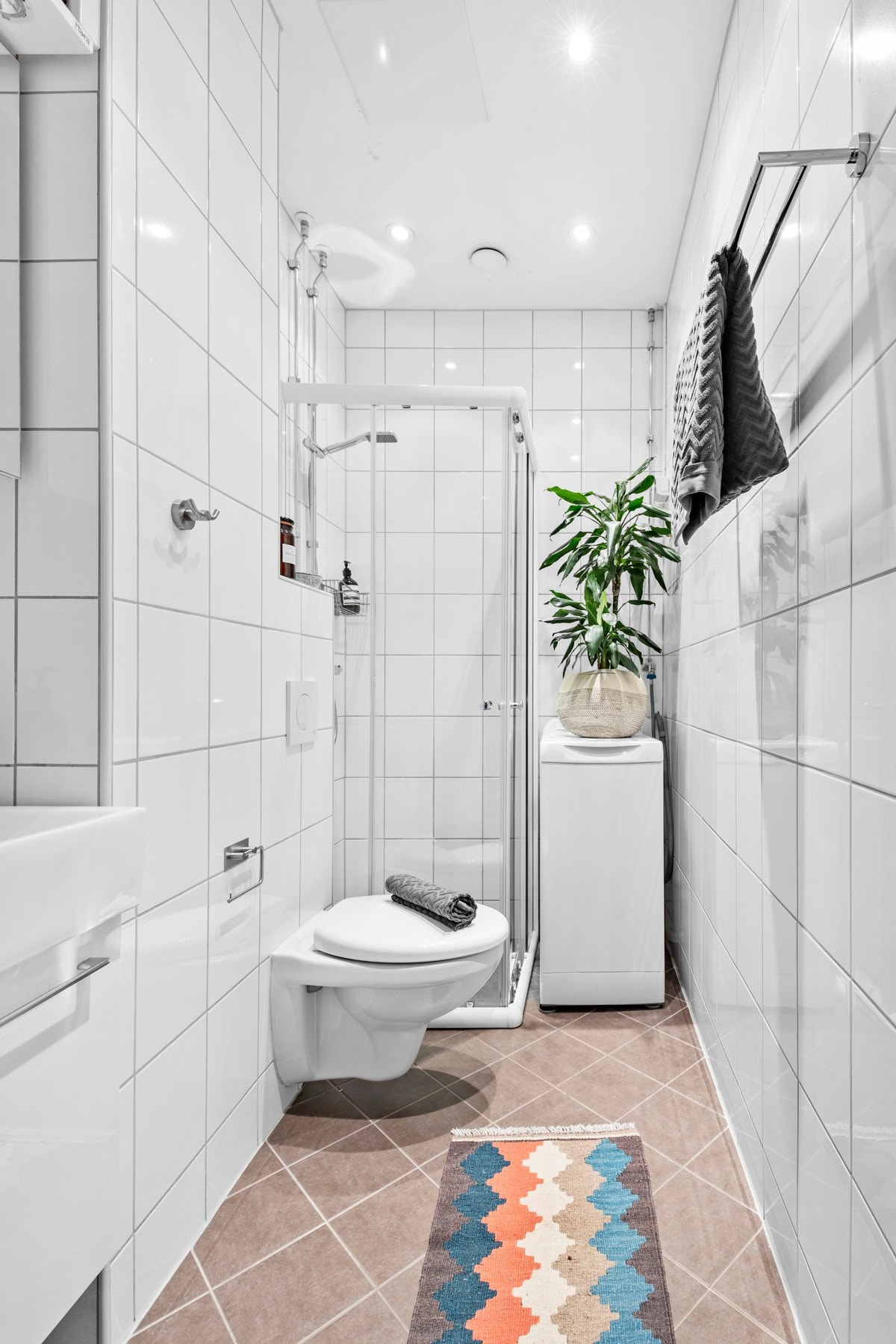 Dette er et godt sted å starte dagen, og varmekabler i gulvet sørger for ekstra komfort i hverdagen. Baderomsinnredningen består av dusj med vegger, vegghengt toalett, servant i skap, speilskap og opplegg vaskemaskin. Galleribilde