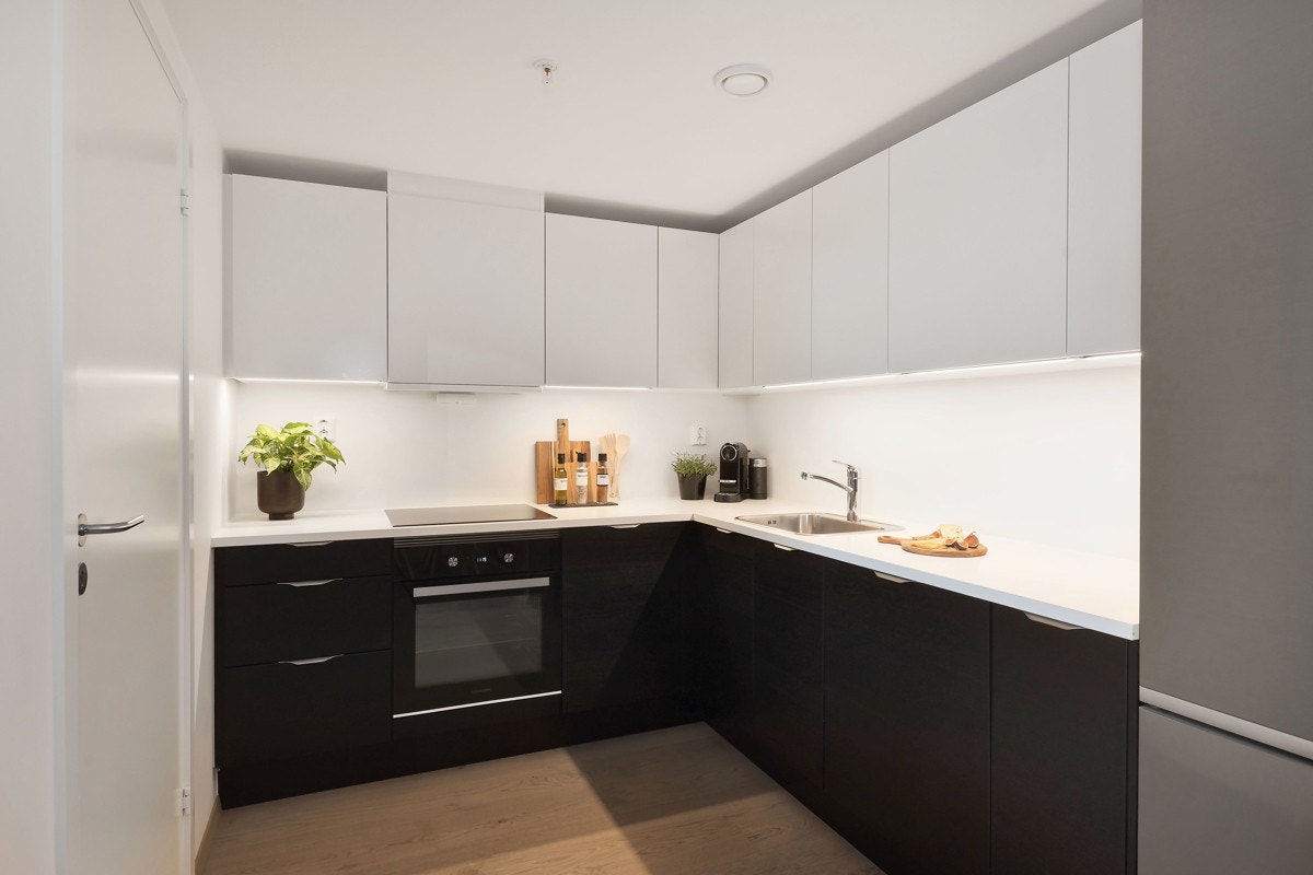 Kjøkkeninnredningen fra HTH er moderne med sorte og hvite, matte fronter og laminert benkeplate. Galleribilde