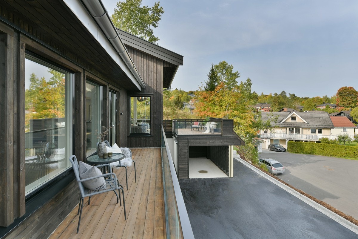 Utenfor stuen er det veranda med noe rekkverk i glass og noe med liggende spiler. Galleribilde